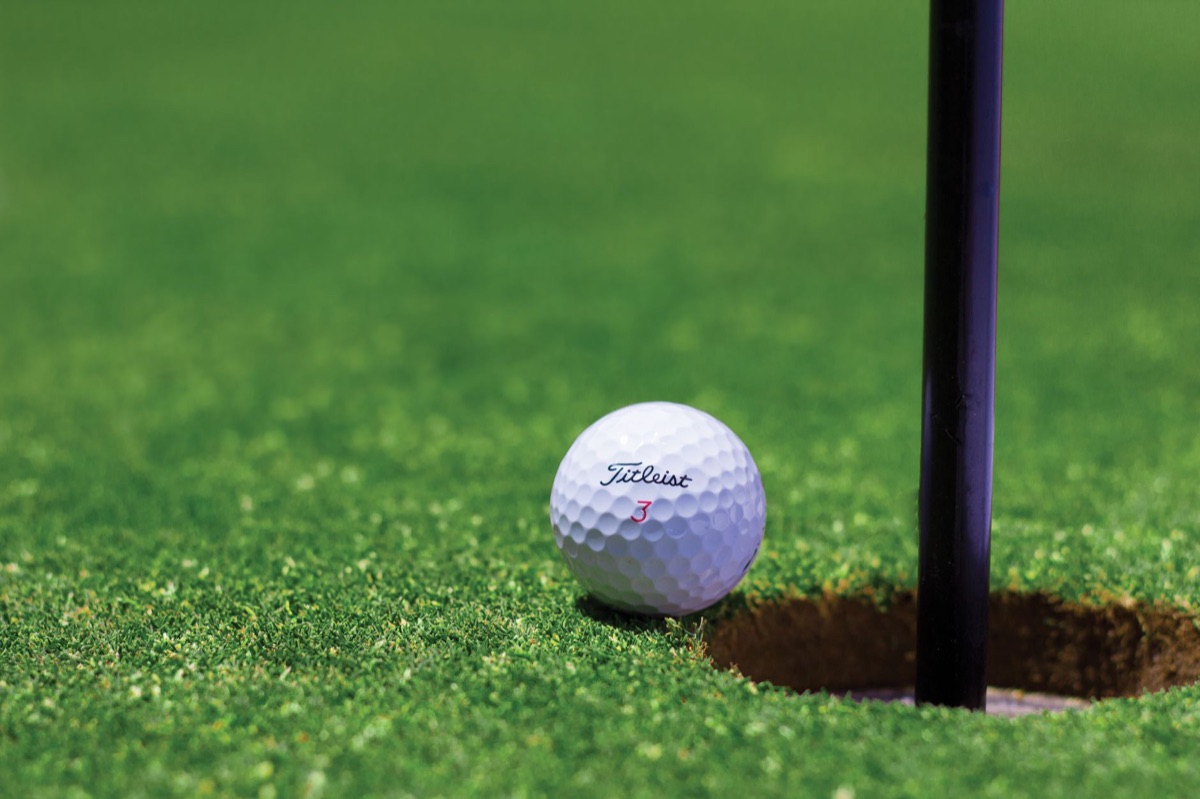 Primo piano di una pallina da golf sull'erba perfetta del fairway