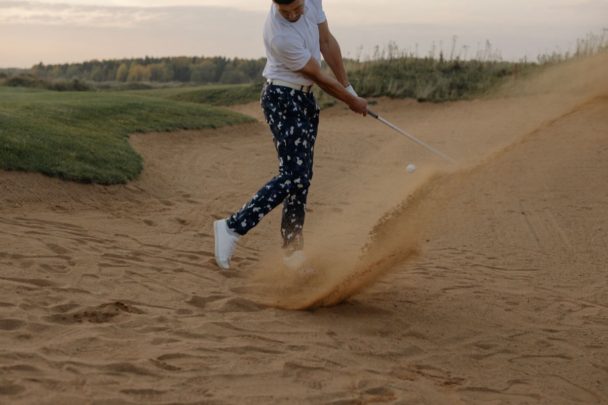 Dettaglio di una pallina da golf su un terreno sabbioso tipico dei links